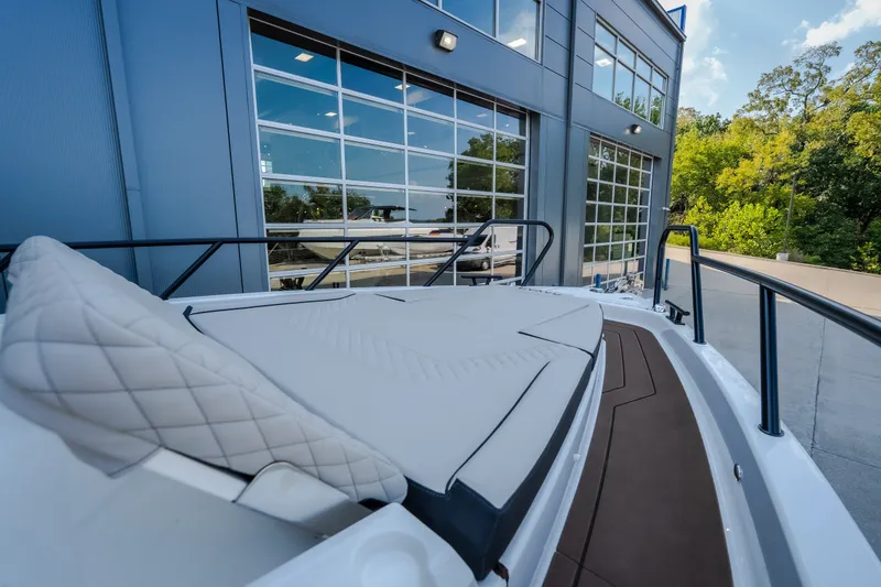 Slide: The Image of 2025 Navan S30 boat with cushioned deck, docked near modern building and lush greenery. - 56