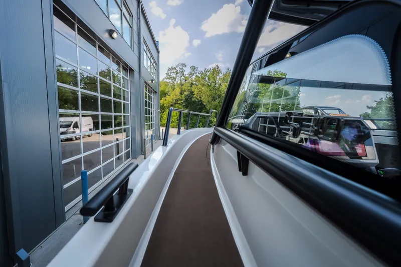Slide: The Image of 2025 Navan S30 boat docked beside a modern building with glass windows. - 34