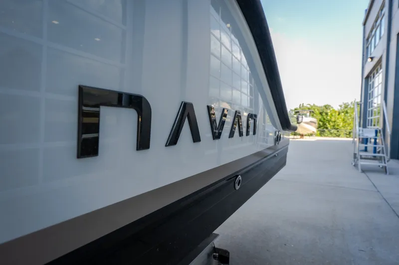 Slide: The Image of 2025 Navan S30 boat exterior with logo, parked outdoors near a building. - 49