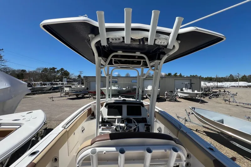 Slide: The Image of 2018 ROBALLO R242 boat interior with steering console and overhead canopy in a marina setting. - 10