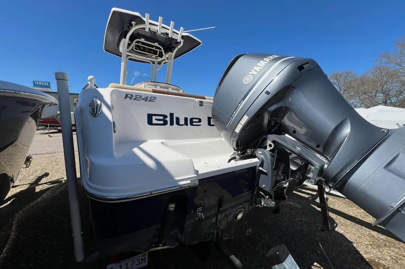 Slide: The Image of 2018 ROBALLO R242 boat with Yamaha engine, parked outdoors under clear blue sky. - 15