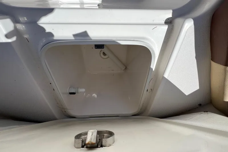 Slide: The Image of Storage compartment on a 2018 ROBALLO R242 boat, featuring a white interior. - 19