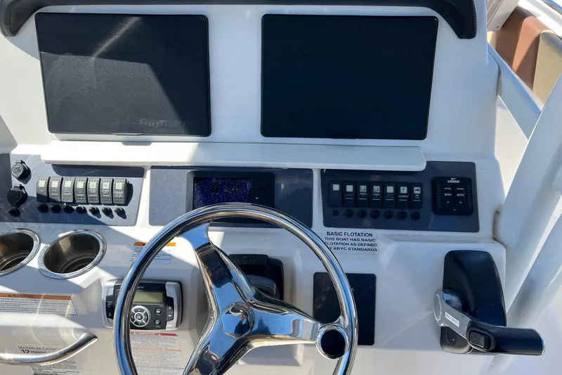 Slide: The Image of 2018 ROBALLO R242 boat dashboard with steering wheel, controls, and navigation screens. - 4