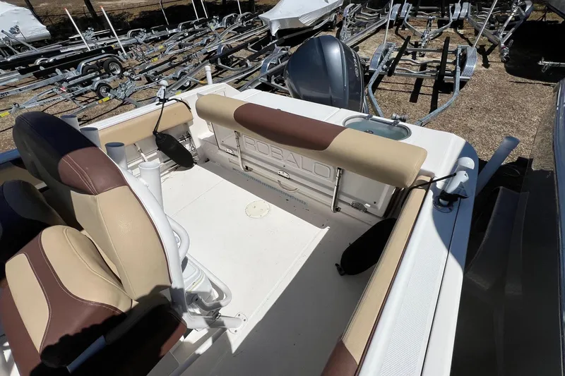 Slide: The Image of 2018 ROBALLO R242 boat interior with beige seating and visible engine area. - 7
