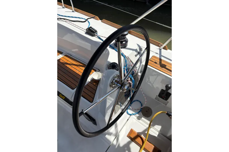 Slide: The Image of Steering wheel of a 2017 Jeanneau Sun Odyssey 349 sailboat, featuring teak decking. - 16