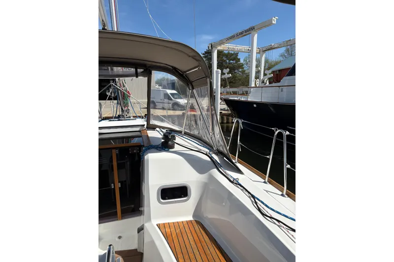 Slide: The Image of 2017 Jeanneau Sun Odyssey 349 sailboat cockpit with marina view, featuring teak seating and rigging. - 20