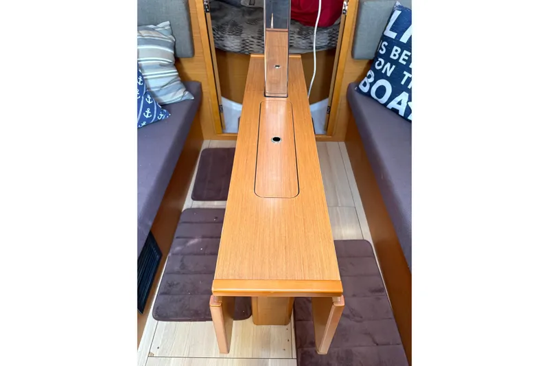 Slide: The Image of Interior of 2017 Jeanneau Sun Odyssey 349 sailboat with wooden table and cozy seating. - 26