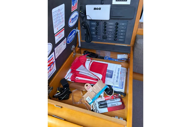 Slide: The Image of Navigation station on a 2017 Jeanneau Sun Odyssey 349 yacht with equipment and manuals. - 39