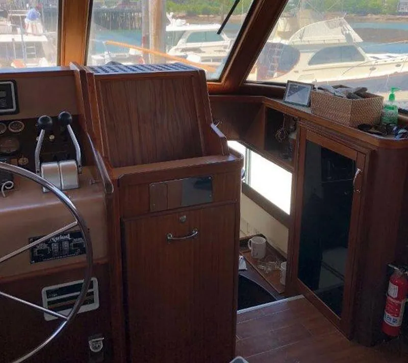 Slide: The Image of 1987 Hatteras Flybridge interior with wooden helm, steering wheel, and control panel. - 12