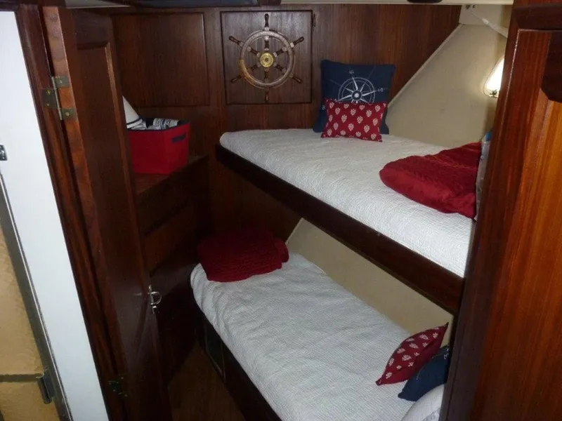 Slide: The Image of 1987 Hatteras Flybridge cabin with wooden interior and bunk beds, nautical-themed decor. - 19
