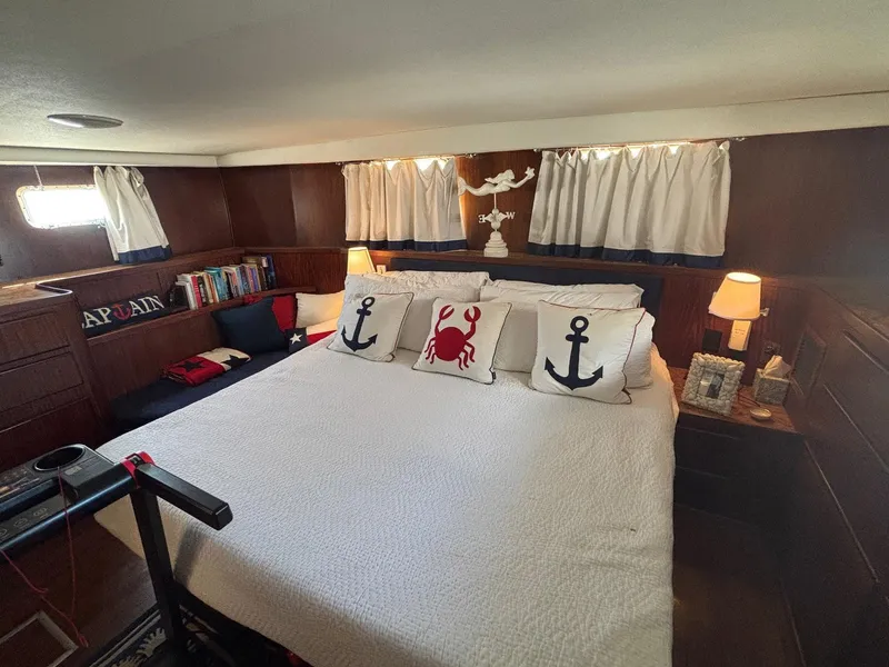 Slide: The Image of Cozy bedroom in 1987 Hatteras Flybridge yacht with nautical-themed decor and plush bedding. - 20