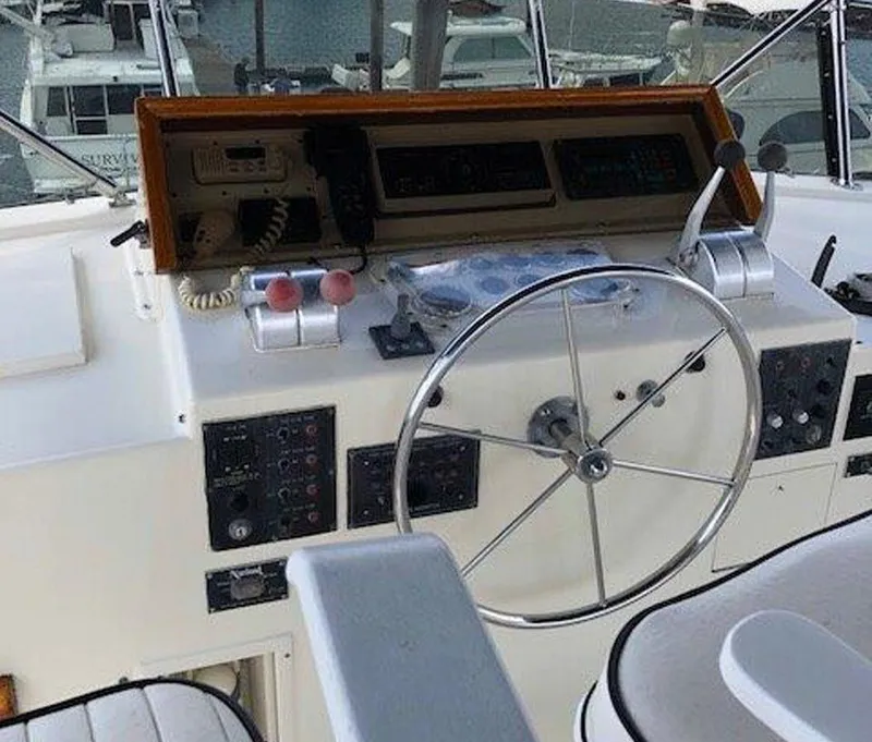 Slide: The Image of 1987 Hatteras Flybridge helm with steering wheel and control panel. - 43
