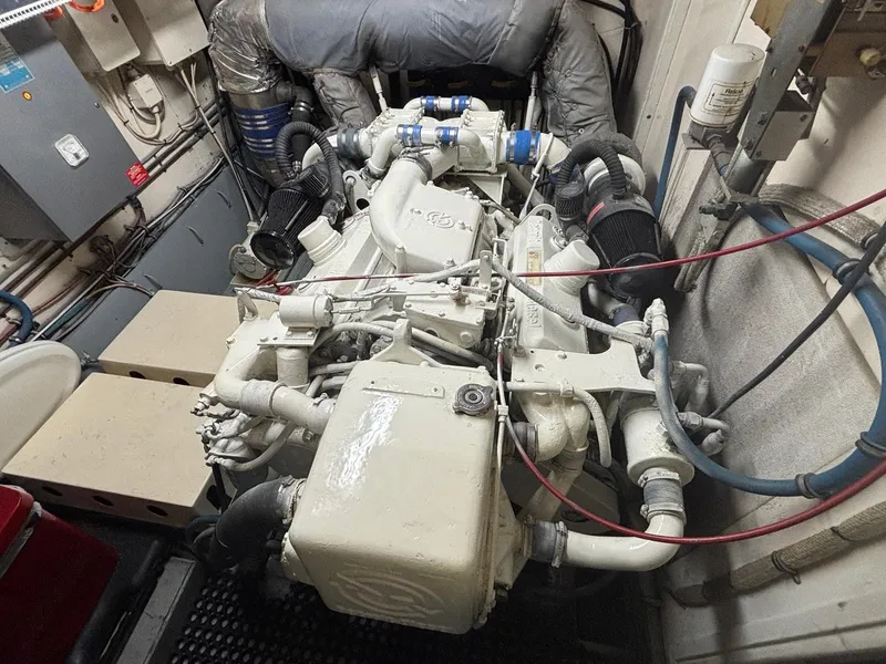 Slide: The Image of Engine room of a 1987 Hatteras Flybridge yacht, showcasing complex machinery and piping. - 45