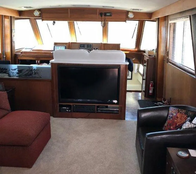 Slide: The Image of Interior of 1987 Hatteras Flybridge yacht with cozy seating and entertainment area. - 7