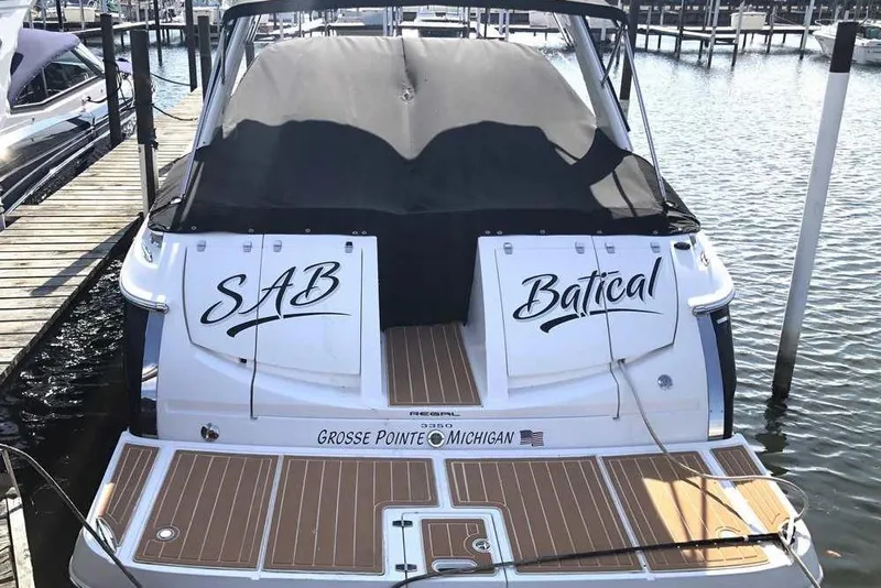Slide: The Image of Freshwater 2007 Regal 3350 Sport Cruiser docked at a marina, featuring sleek black and white design. - 3