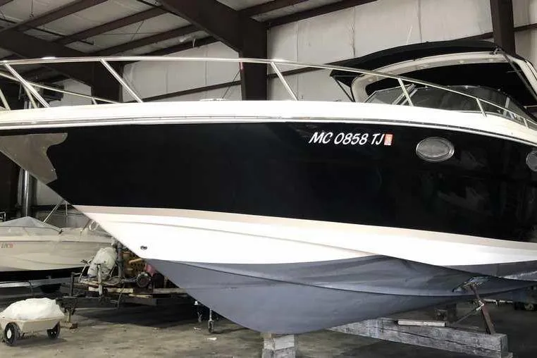 Slide: The Image of 2007 Regal 3350 Sport Cruiser in storage, black and white hull, indoor facility. - 5