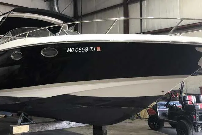 Slide: The Image of 2007 Regal 3350 Sport Cruiser in storage, black and white hull, indoor facility. - 7