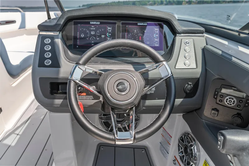 Slide: The Image of 2022 Chaparral 247 SSX boat dashboard with steering wheel and digital display. - 11