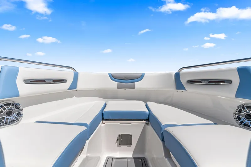 Slide: The Image of 2022 Chaparral 247 SSX boat interior with blue and white seating under a clear sky. - 12