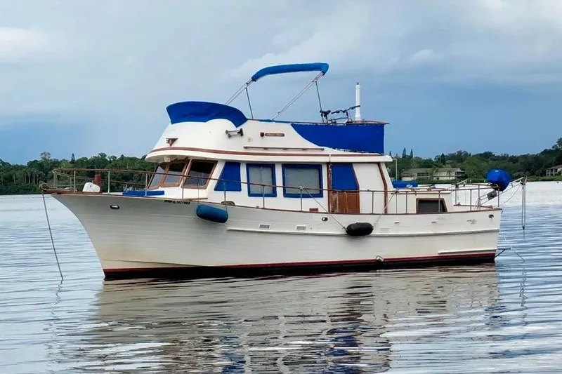 The Image of 1981 Albin 36 Trawler on calm water with blue canopy and white hull. - 1