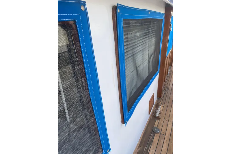 Slide: The Image of 1981 Albin 36 Trawler with blue-trimmed windows and wooden deck details. - 16