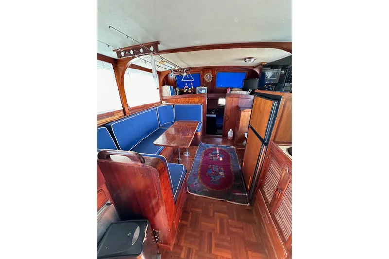 Slide: The Image of Interior of 1981 Albin 36 Trawler with blue seating, wooden finishes, and nautical decor. - 26
