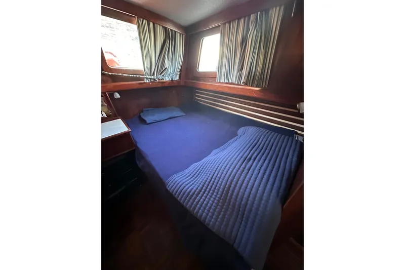 Slide: The Image of Cozy cabin interior of 1981 Albin 36 Trawler with blue bedding and striped curtains. - 32