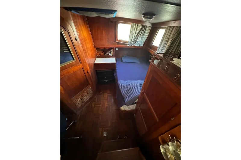 Slide: The Image of Cozy cabin interior of 1981 Albin 36 Trawler with wooden furnishings and blue bedding. - 34