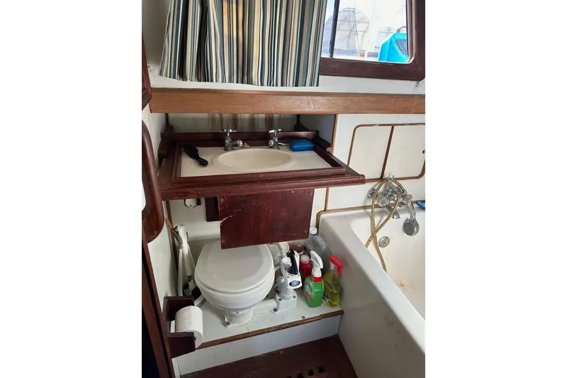Slide: The Image of Bathroom of 1981 Albin 36 Trawler with sink, toilet, and cleaning supplies. - 35