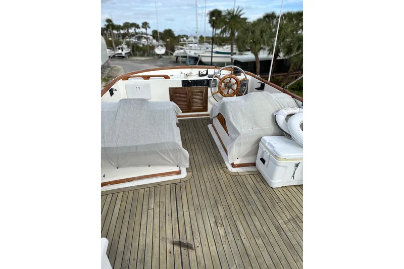 Slide: The Image of 1981 Albin 36 Trawler deck with wooden flooring and covered seating area. - 37