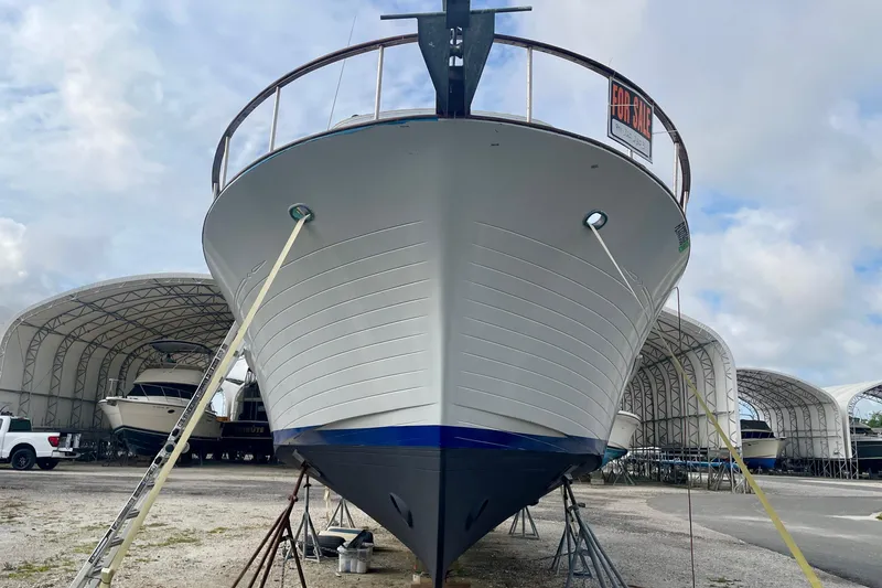 Slide: The Image of 1981 Albin 36 Trawler for sale, docked in a boatyard under cloudy skies. - 5