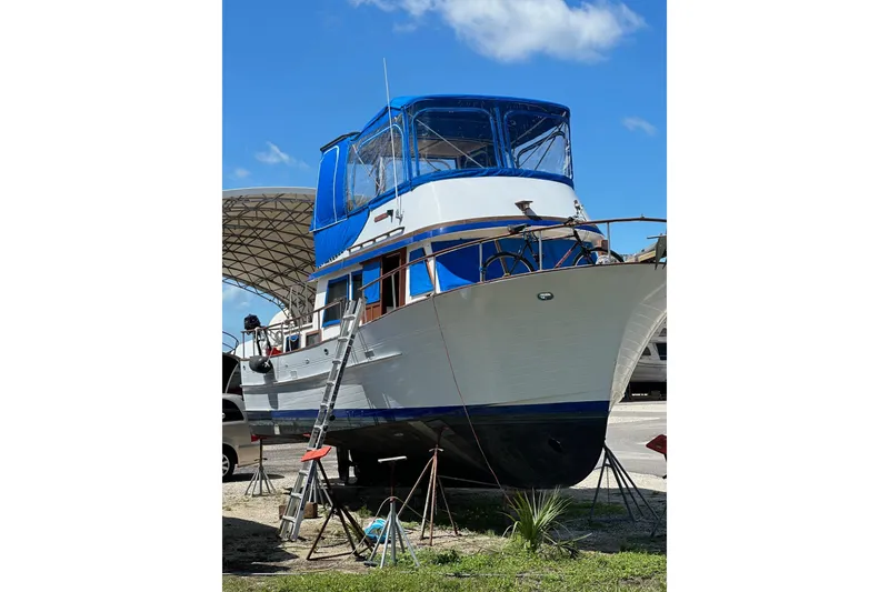 Slide: The Image of 1981 Albin 36 Trawler on stands, blue canopy, clear sky background. - 7