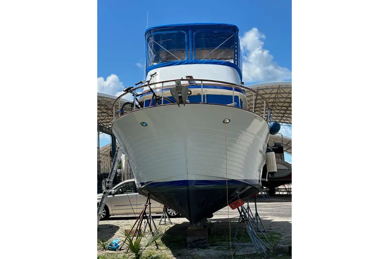 Slide: The Image of 1981 Albin 36 Trawler on dry dock, blue canopy, sunny day. - 8