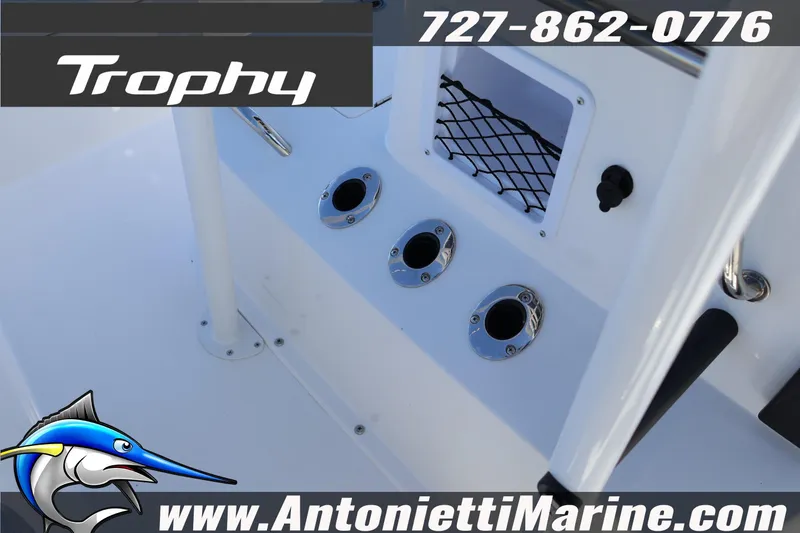 Slide: The Image of 2026 Bayliner Trophy T18 boat interior with rod holders and storage net. - 24