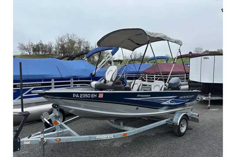 The Image of 2025 Smoker Craft Resorter 151 boat on trailer with canopy, parked outdoors. - 0