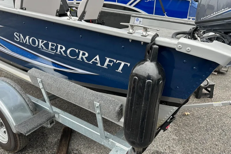 Slide: The Image of 2025 Smoker Craft Resorter 151 boat on trailer, featuring blue exterior and protective fender. - 11