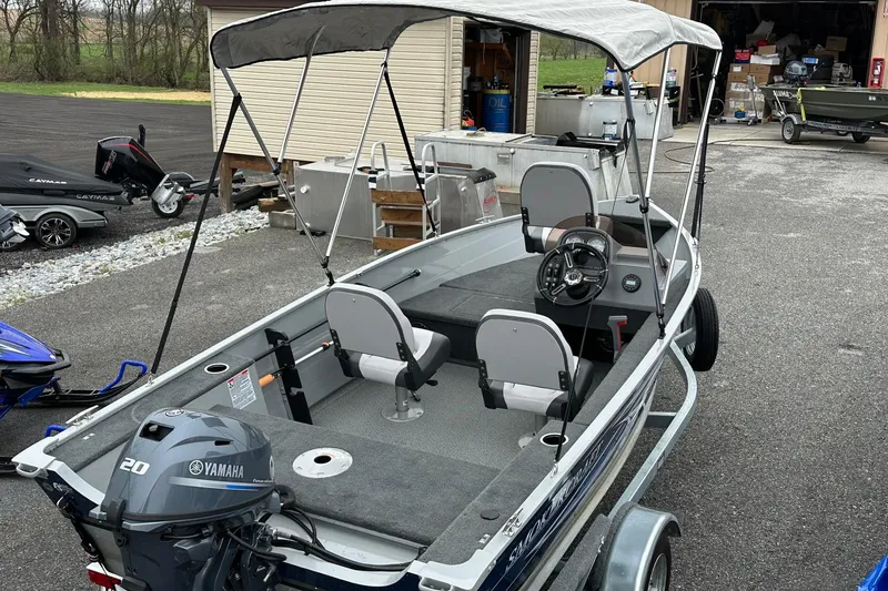 Slide: The Image of 2025 Smoker Craft Resorter 151 boat with Yamaha motor, parked outdoors. - 14
