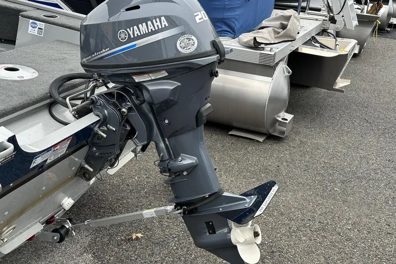 Slide: The Image of 2025 Smoker Craft Resorter 151 with Yamaha outboard motor, parked on asphalt. - 15