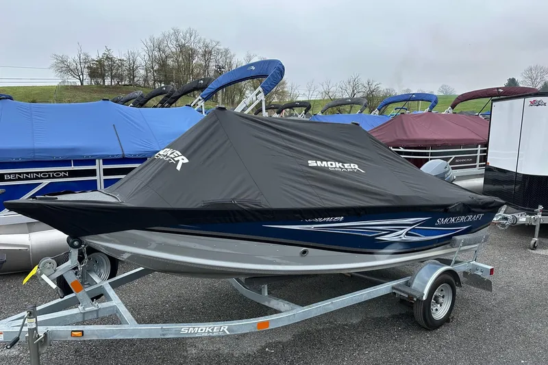 Slide: The Image of 2025 Smoker Craft Resorter 151 boat on trailer, covered, parked outdoors. - 16