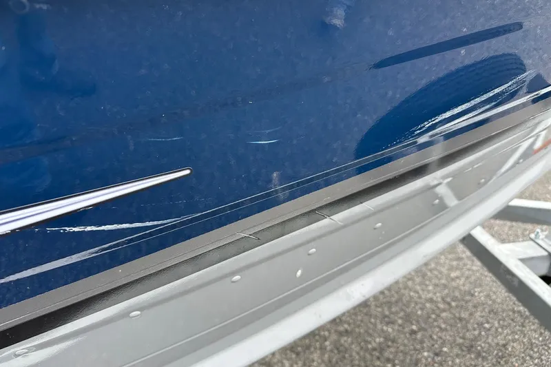 Slide: The Image of 2025 Smoker Craft Resorter 151 boat with visible scratches on blue hull. - 6