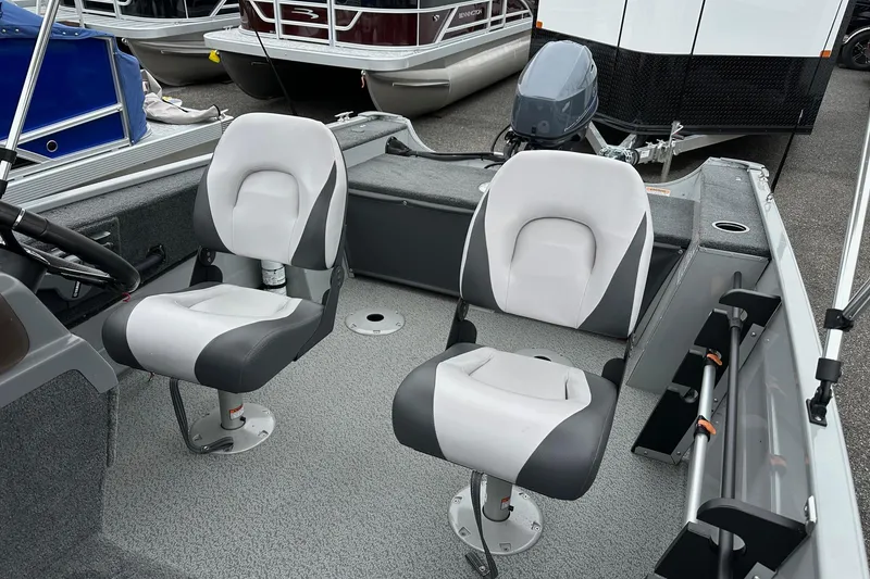 Slide: The Image of 2025 Smoker Craft Resorter 151 boat interior with two swivel seats and motor. - 8