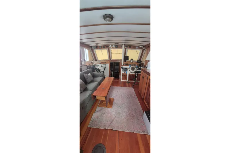 Slide: The Image of Interior of 1988 Custom Holland Wesmac-Foley Flybridge Cruiser with wooden furnishings and cozy seating. - 10