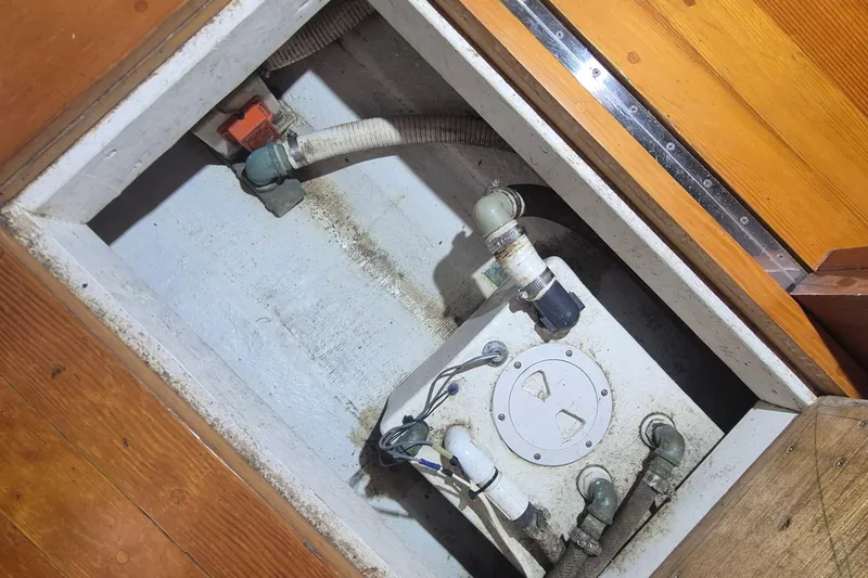 Slide: The Image of Bilge compartment of 1988 Custom Holland Wesmac-Foley Flybridge Cruiser with visible pipes and fittings. - 107