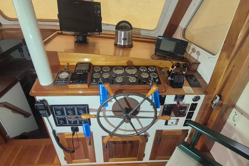 Slide: The Image of Helm of 1988 Custom Holland Wesmac-Foley Flybridge Cruiser with navigation instruments and wooden wheel. - 11