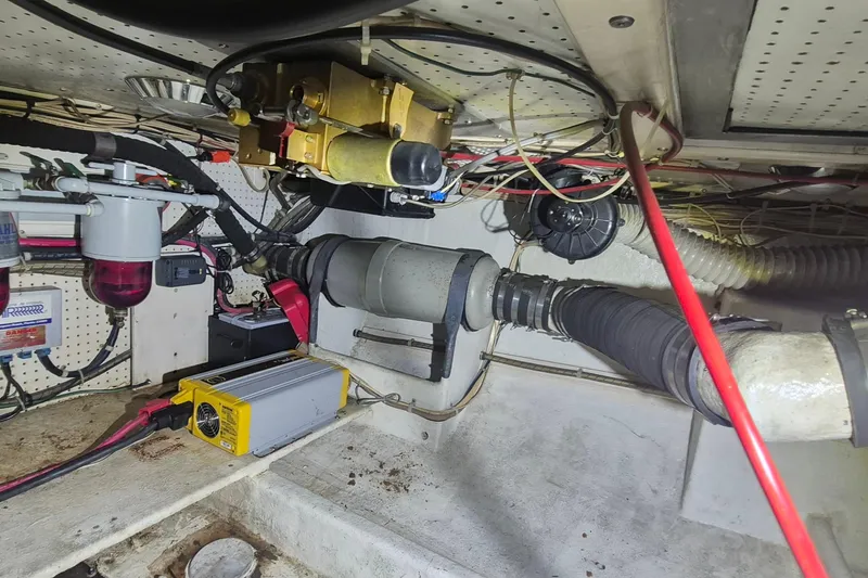 Slide: The Image of Engine room of 1988 Custom Holland Wesmac-Foley Flybridge Cruiser, showcasing mechanical components and wiring. - 111