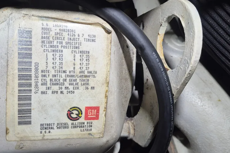 Slide: The Image of Label on engine component with timing and valve lash specifications, GM logo visible. - 114