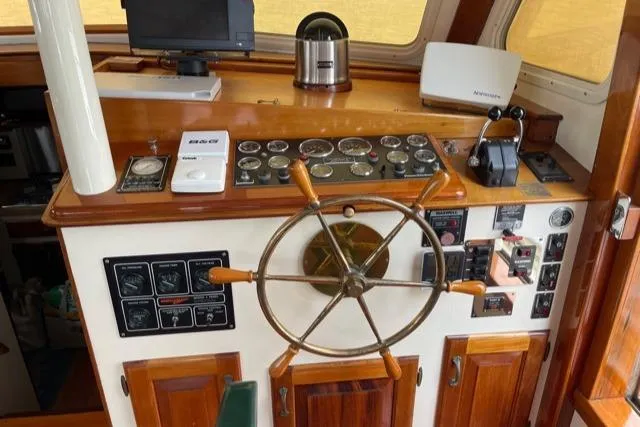 Slide: The Image of 1988 Holland Wesmac-Foley Flybridge Cruiser helm with wooden steering wheel. - 12