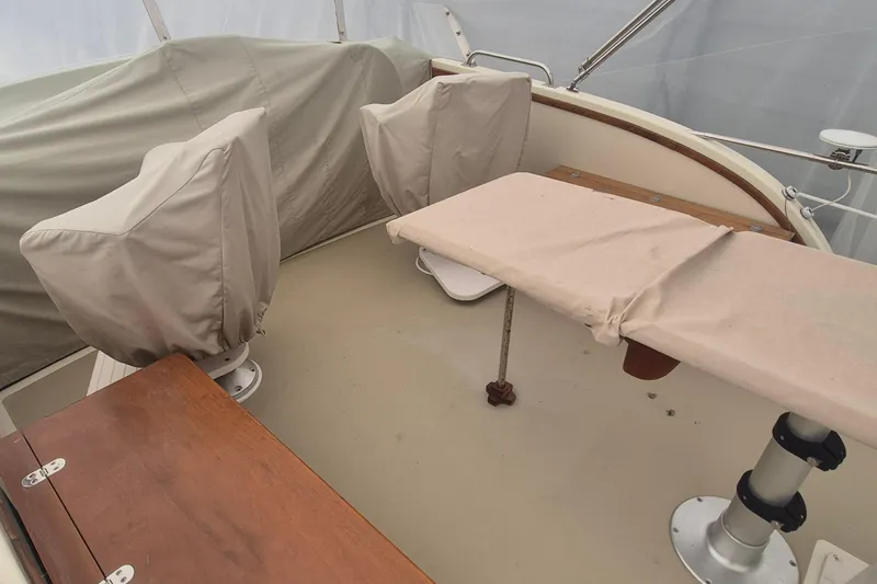 Slide: The Image of 1988 Custom Holland Wesmac-Foley Flybridge Cruiser interior with covered seating and table. - 120