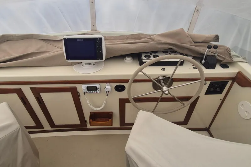 Slide: The Image of 1988 Custom Holland Wesmac-Foley Flybridge Cruiser helm with steering wheel and navigation equipment. - 123