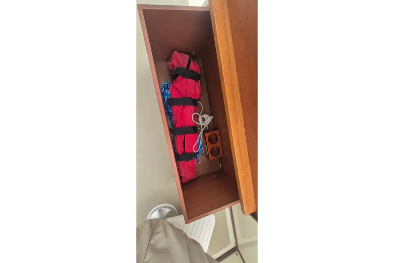 Slide: The Image of Storage compartment on 1988 Custom Holland Wesmac-Foley Flybridge Cruiser with red life jackets and ropes. - 124